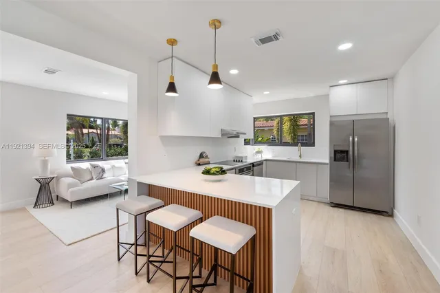a kitchen with kitchen island a large counter top space and stainless steel appliances
