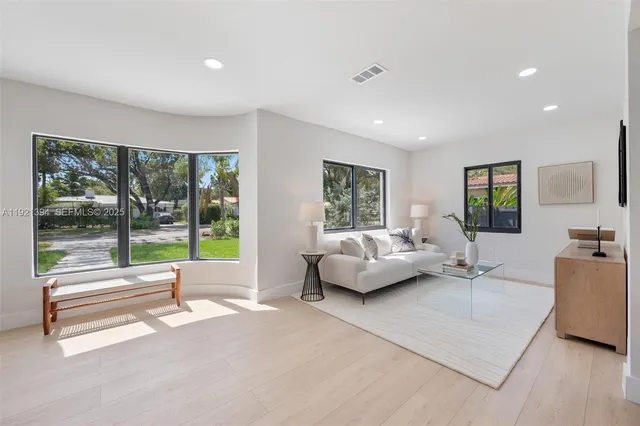 a living room with couch floor to ceiling window and flat screen tv