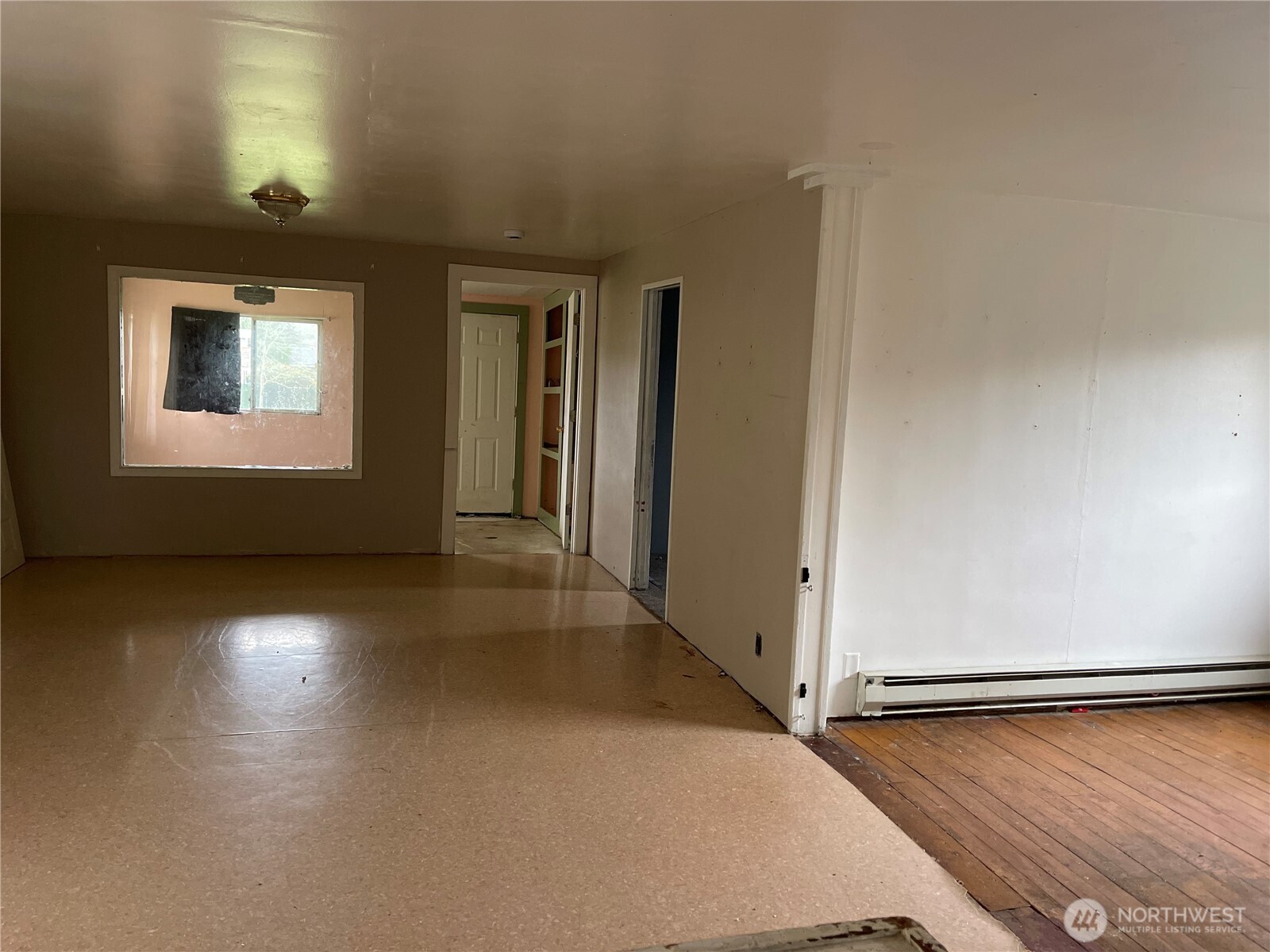 606 West Schley Street Aberdeen, WA 98520 - Photo 7 of 19 an empty room with wooden floor and windows