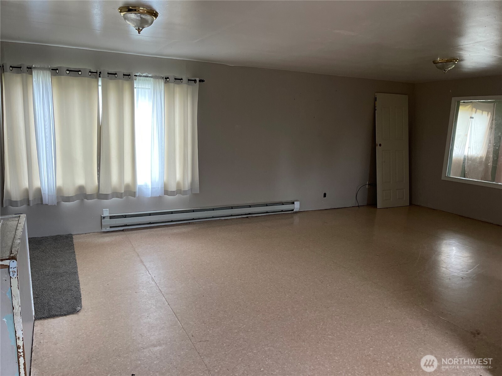606 West Schley Street Aberdeen, WA 98520 - Photo 8 of 19 an empty room with wooden floor and windows