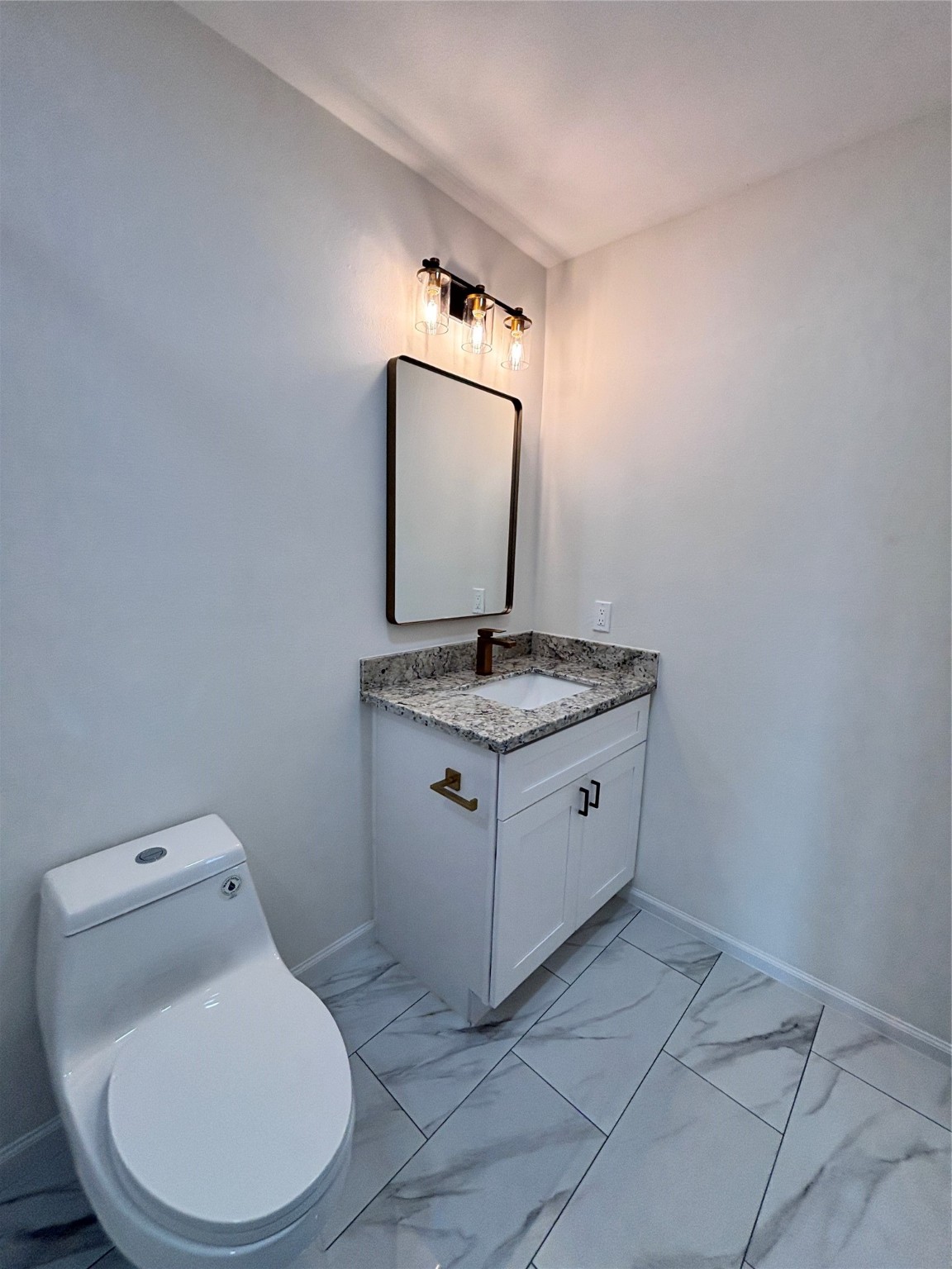 9913 Porto Rico Road, Unit B Houston, TX 77041 - Photo 17 of 26 a bathroom with a granite countertop toilet sink and mirror