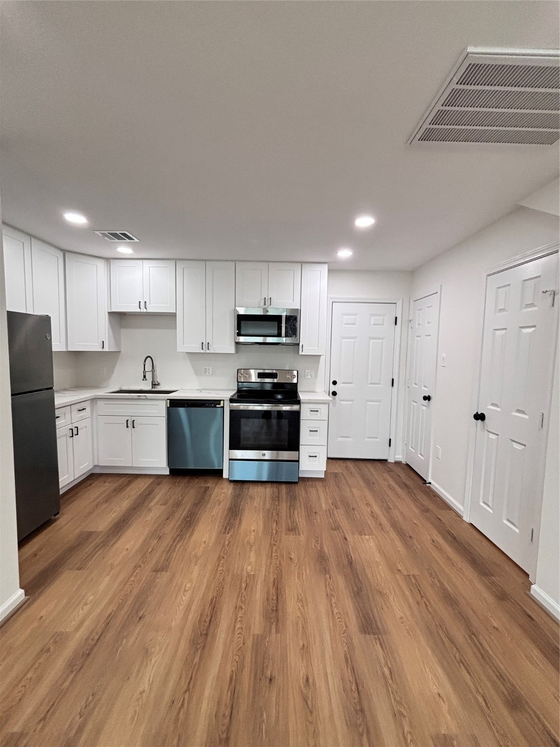 9913 Porto Rico Road, Unit B Houston, TX 77041 - Photo 6 of 26 a large kitchen with wooden floors and stainless steel appliances