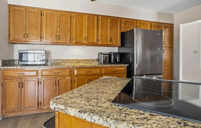 a kitchen with stainless steel appliances granite countertop a refrigerator sink and cabinets