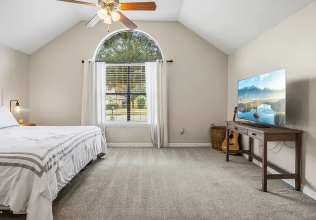 a bedroom with a bed a table and a window