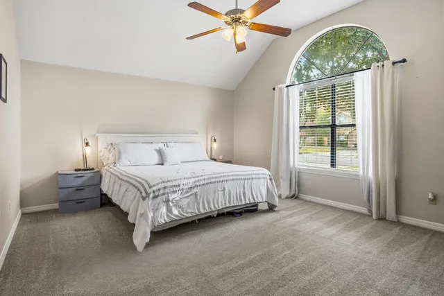 a spacious bedroom with a bed and a chandelier