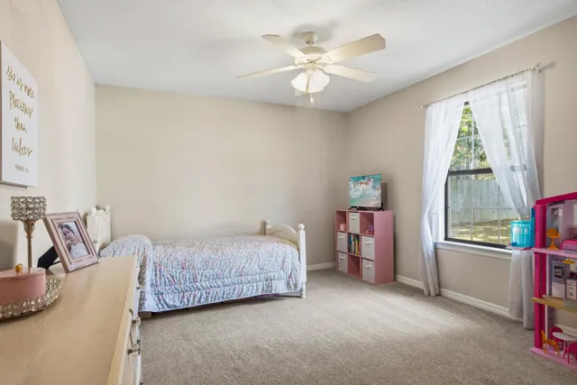 a bedroom with a bed and a flat tv screen on the dresser