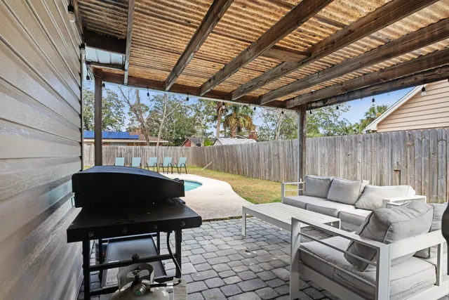 a view of a patio with table and chairs with wooden floor and fence