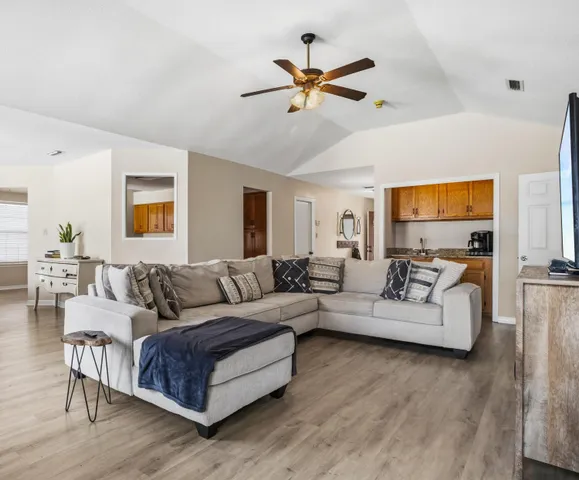 a living room with furniture ceiling fan and a wooden floor