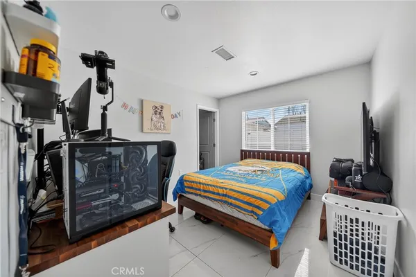 a living room with furniture and a refrigerator