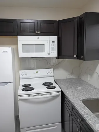 a kitchen with granite countertop a sink and a stove