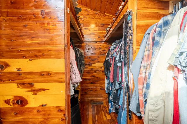 a view of walk in closet with clothes and shoes