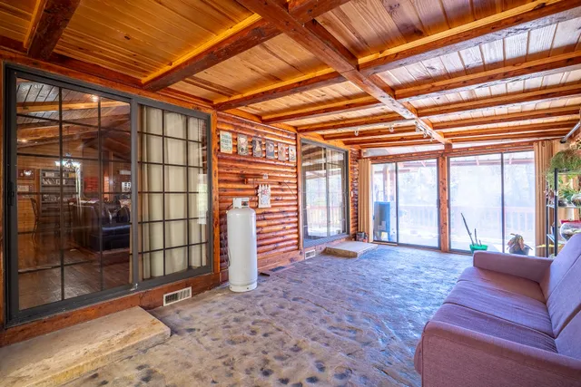 a view of a hall with wooden floor and iron stairs