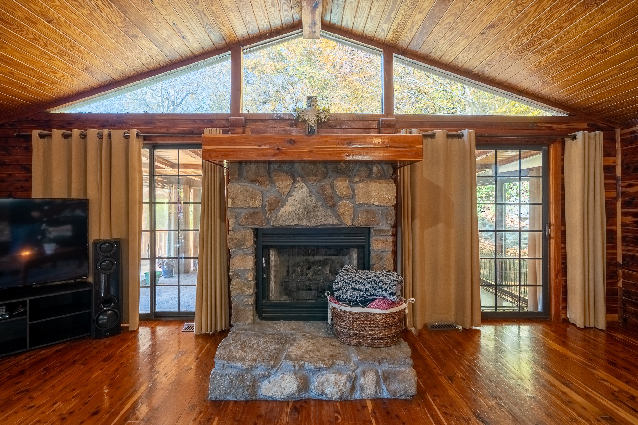 999 Rainbow Lake Road Waynesboro, TN 38485 - Photo 8 of 44 a living room with a fireplace a flat screen tv and a floor to ceiling window
