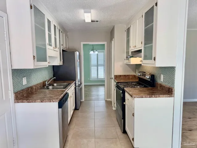 a kitchen with stainless steel appliances granite countertop a stove and a refrigerator