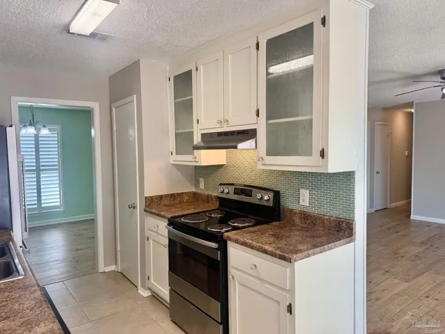 a kitchen with granite countertop a stove and a sink