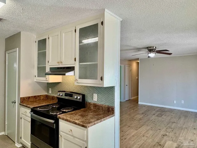 a kitchen with granite countertop a sink stove and refrigerator