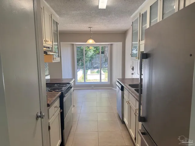 a kitchen with granite countertop a stove and a refrigerator