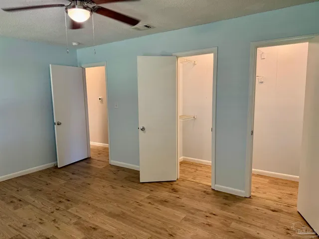 an empty room with wooden floor and window