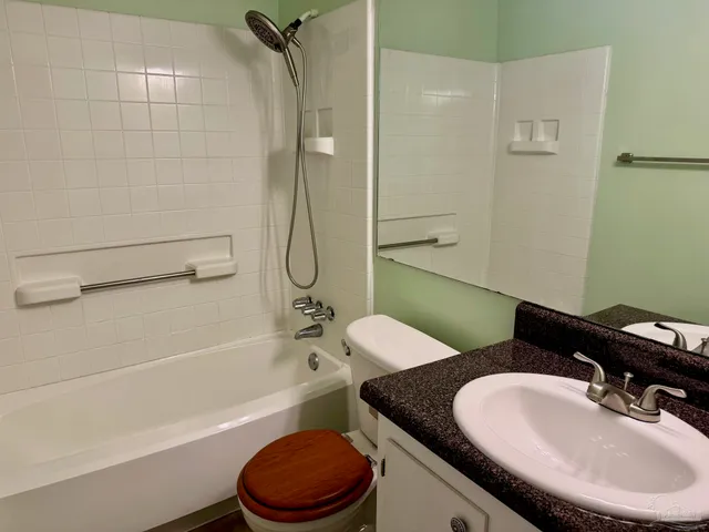 a bathroom with a granite countertop sink mirror toilet and bathtub