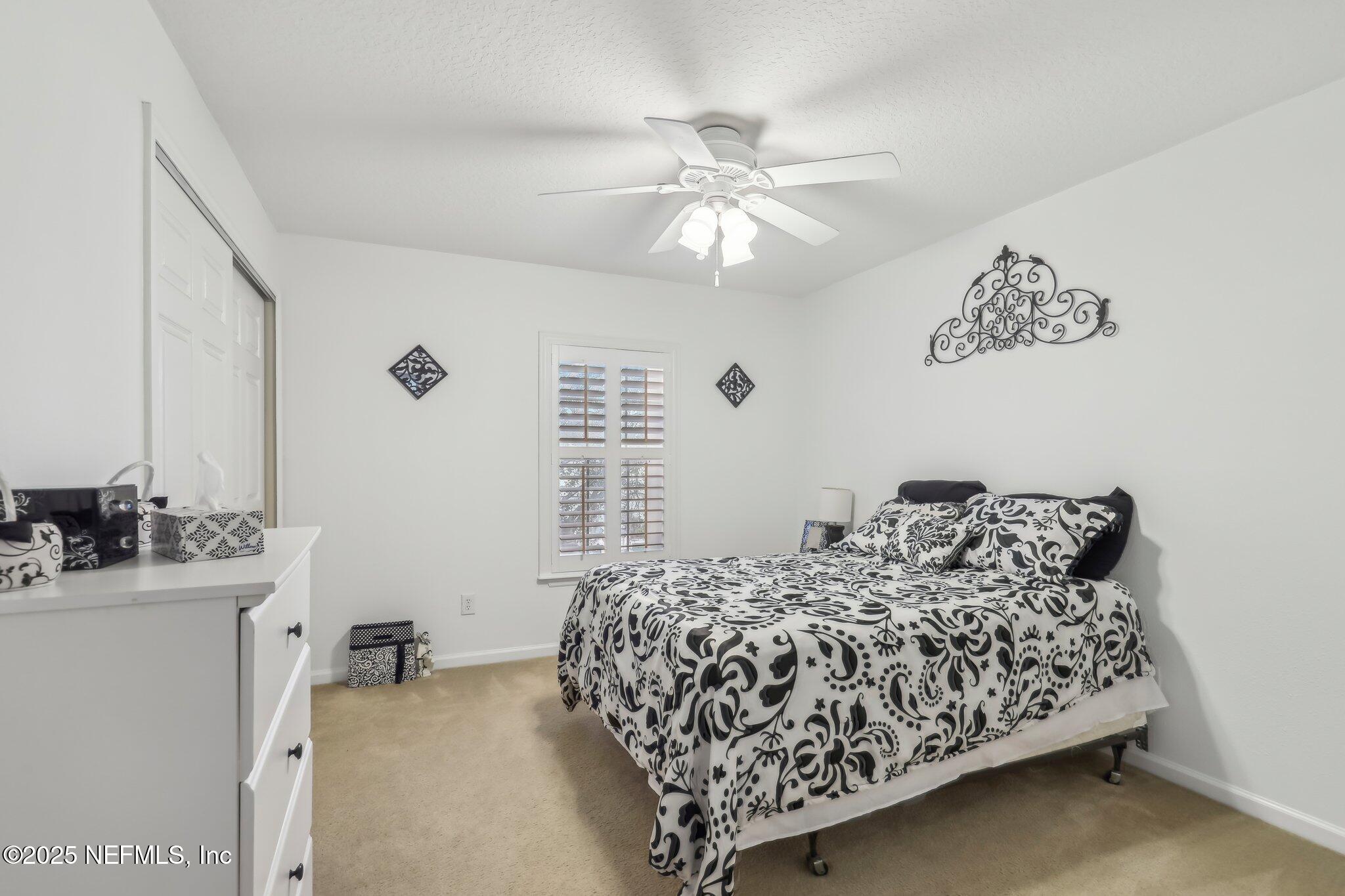 216 Brantley Harbor Drive St. Augustine, FL 32086 - Photo 17 of 33 a bedroom with a bed and a chandelier