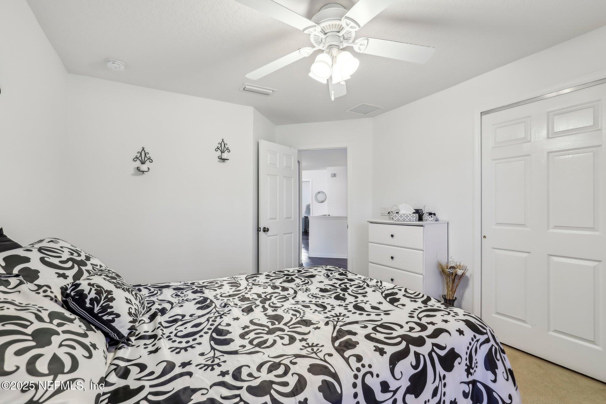 216 Brantley Harbor Drive St. Augustine, FL 32086 - Photo 18 of 33 a bedroom with a bed and a chandelier