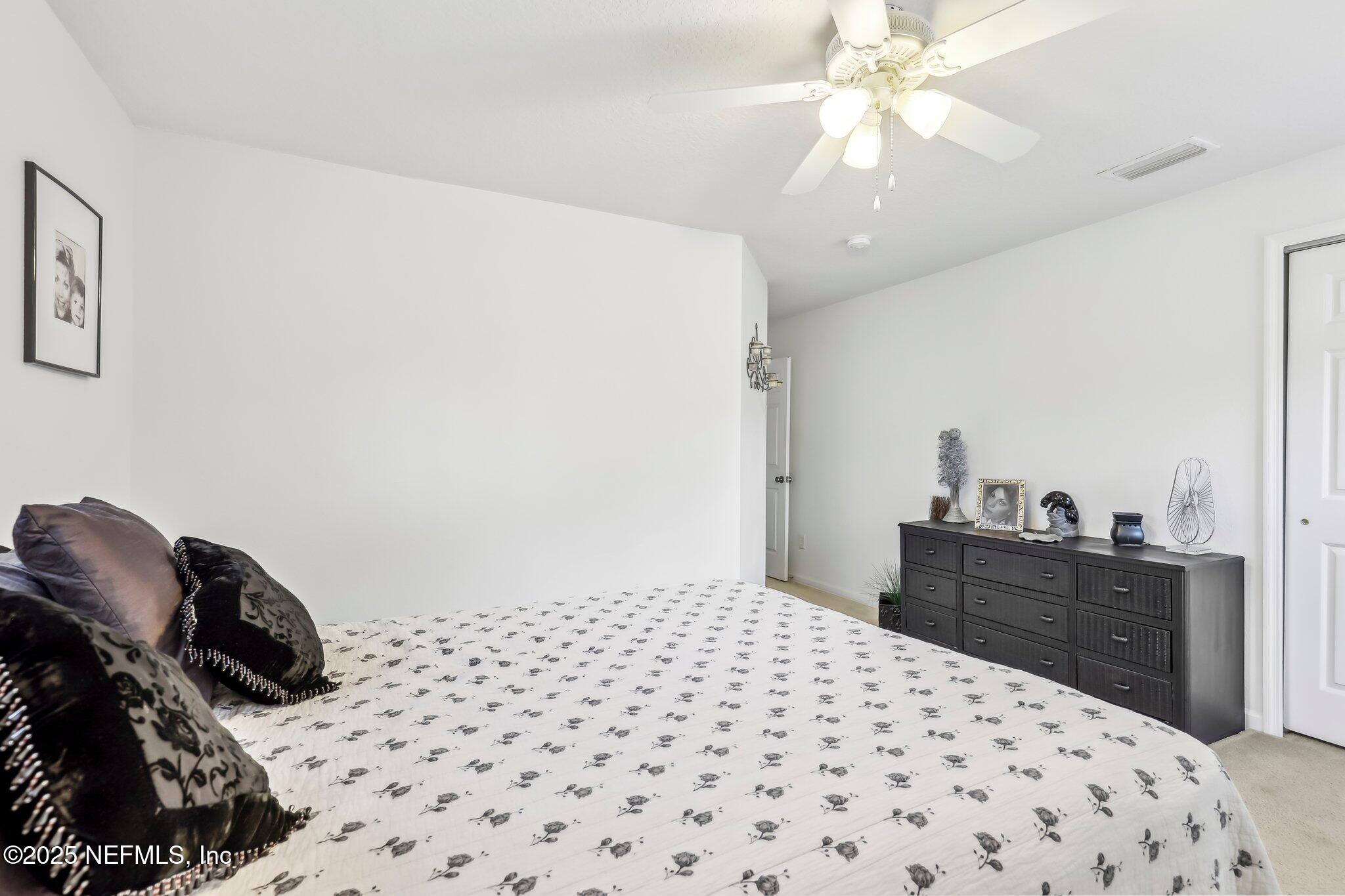 216 Brantley Harbor Drive St. Augustine, FL 32086 - Photo 20 of 33 a bedroom with a bed and a chandelier