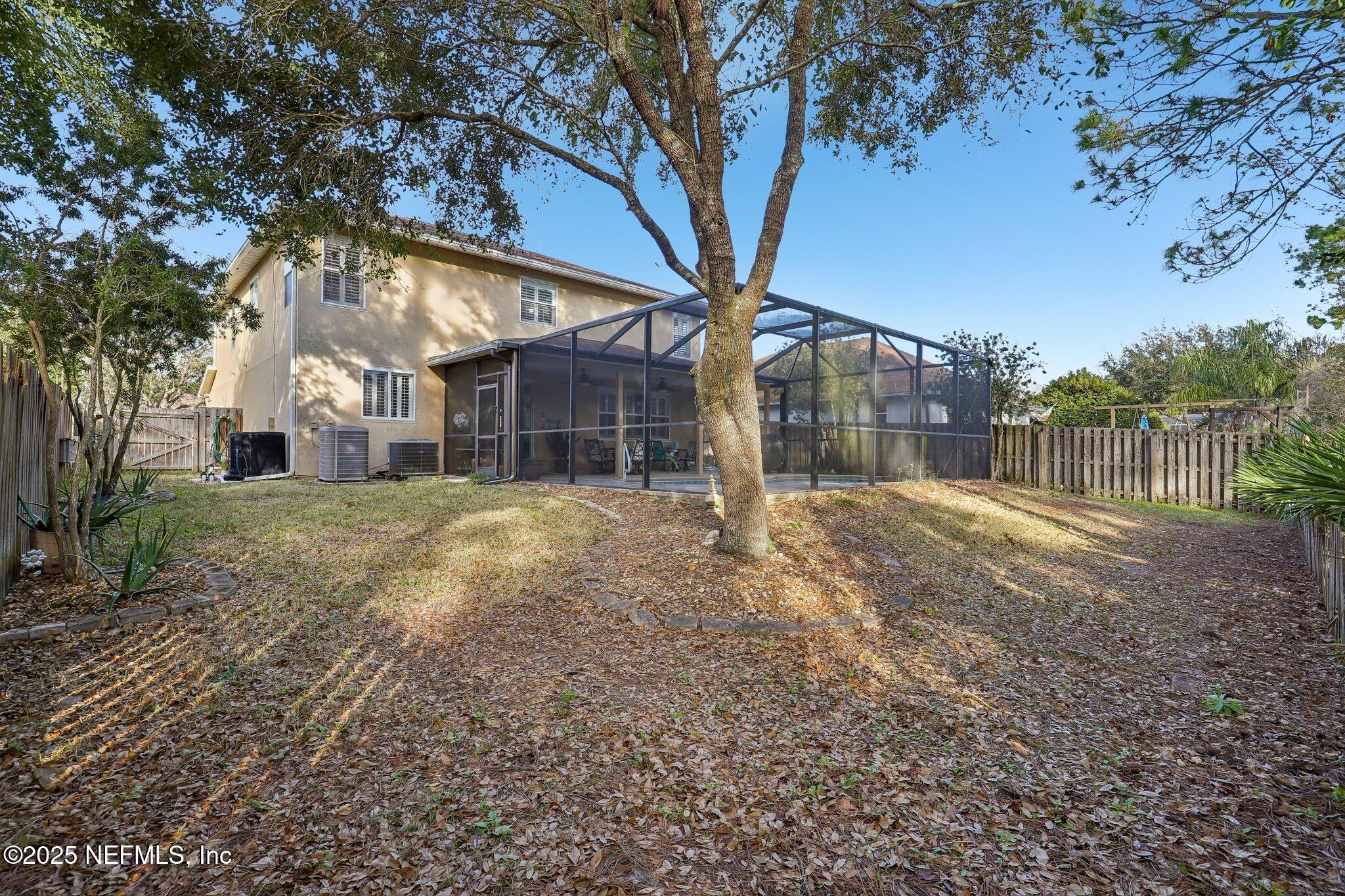 216 Brantley Harbor Drive St. Augustine, FL 32086 - Photo 31 of 33 a backyard of a house with large trees and outdoor seating
