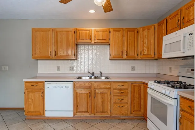 a kitchen with granite countertop a sink stove and cabinets