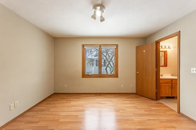 a view of an empty room with window and closet area