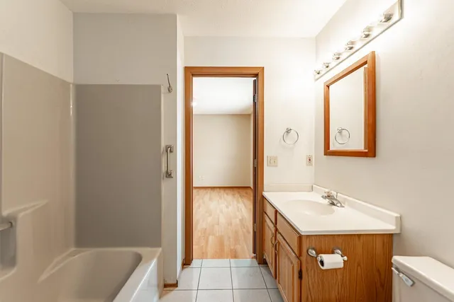 a bathroom with a tub sink and mirror