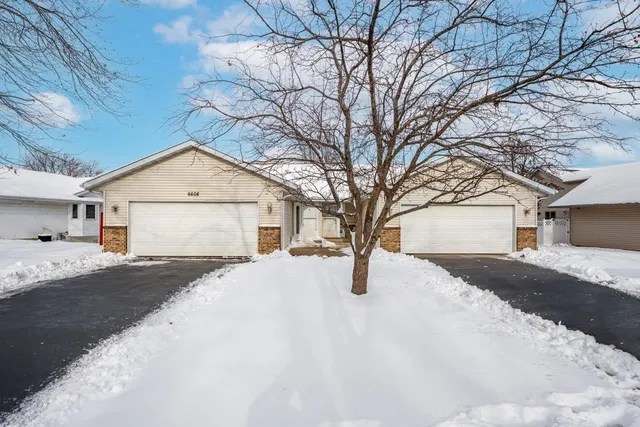 a yellow house with snow on the road
