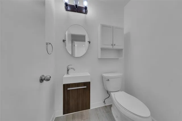 an empty room with wooden floor ceiling fan and windows