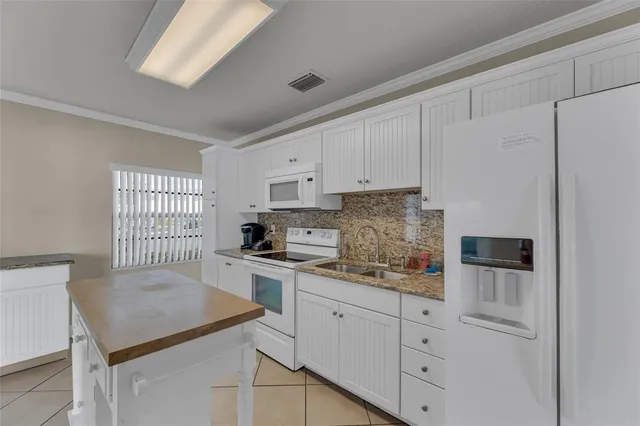 a kitchen with white cabinets and sink