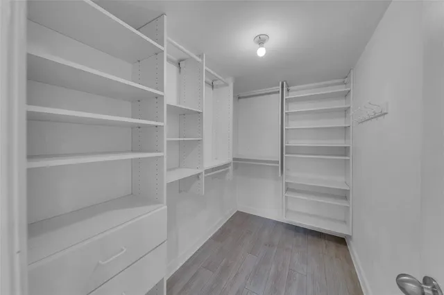 a kitchen with cabinets wooden floor and stainless steel appliances