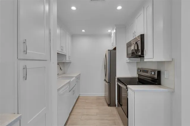 a kitchen with stainless steel appliances white cabinets and a sink