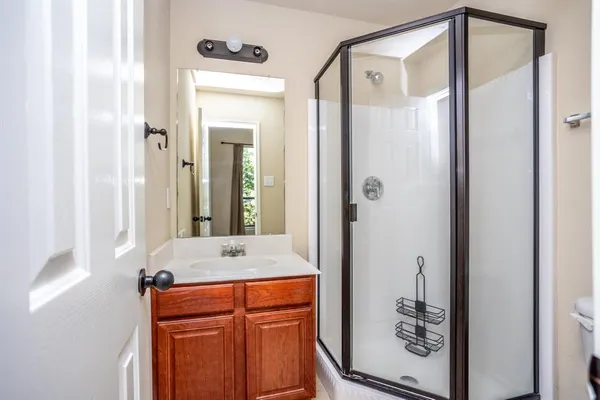 a bathroom with a mirror a shower and a sink