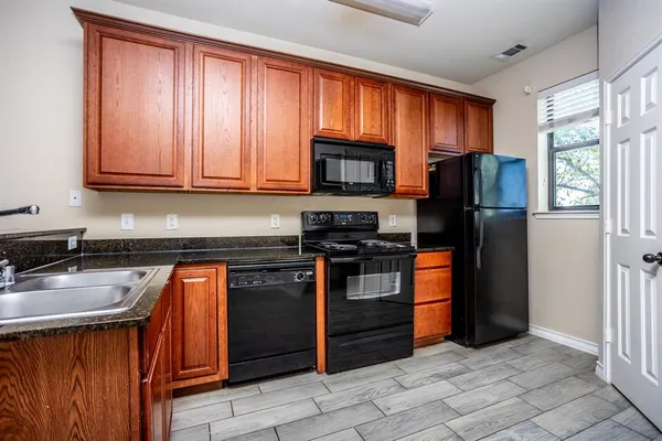 a kitchen with stainless steel appliances granite countertop a stove sink microwave and refrigerator