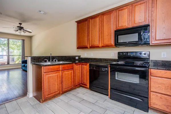 a kitchen with granite countertop stainless steel appliances a stove a sink and a microwave