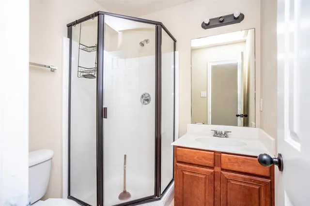 a en suite bathroom with a shower sink and mirror