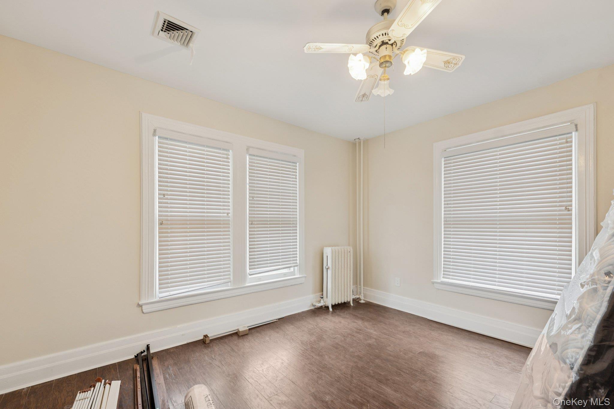 397 Split Rock Road Syosset, NY 11791 - Photo 19 of 29 a view of an empty room with a window and wooden floor
