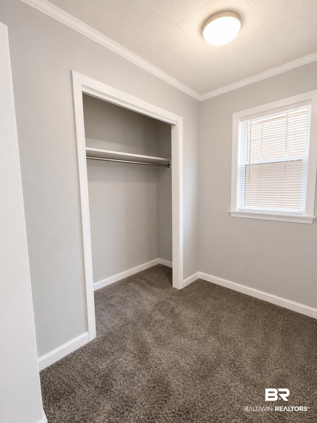 226 Elizabeth Street Evergreen, AL 36401 - Photo 20 of 35 Room featuring light gray walls, white crown molding, and a textured ceiling