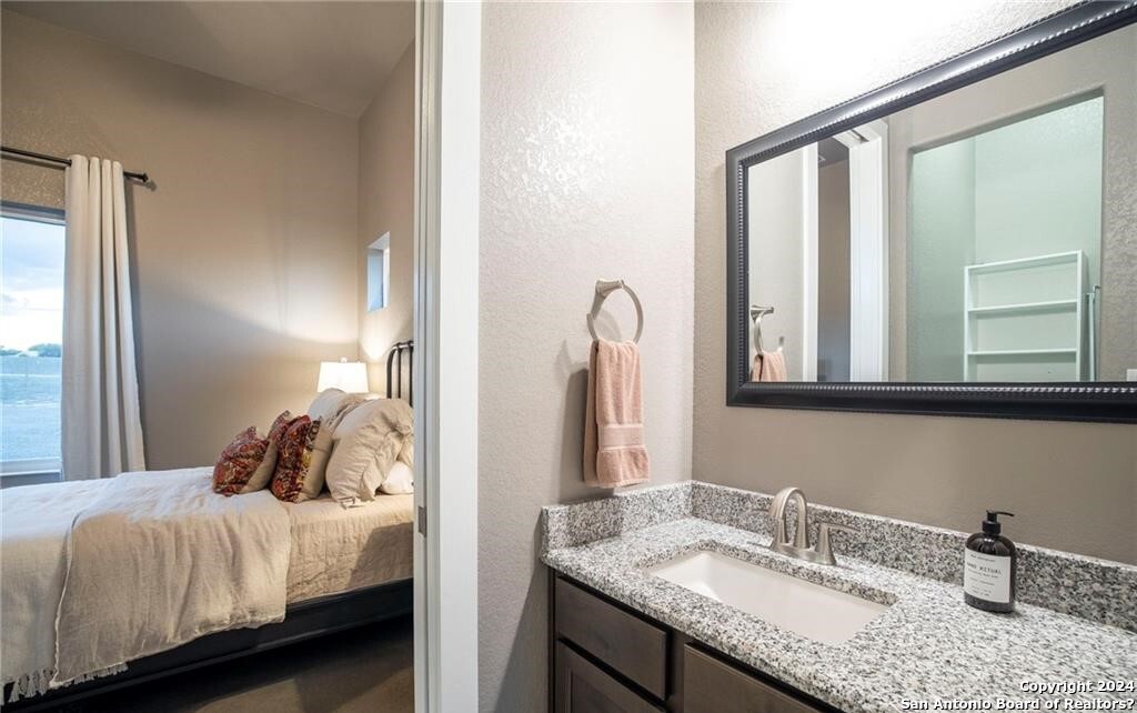 345 Laguna Road Bandera, TX 78003 - Photo 18 of 35 a bathroom with a granite countertop sink and a mirror