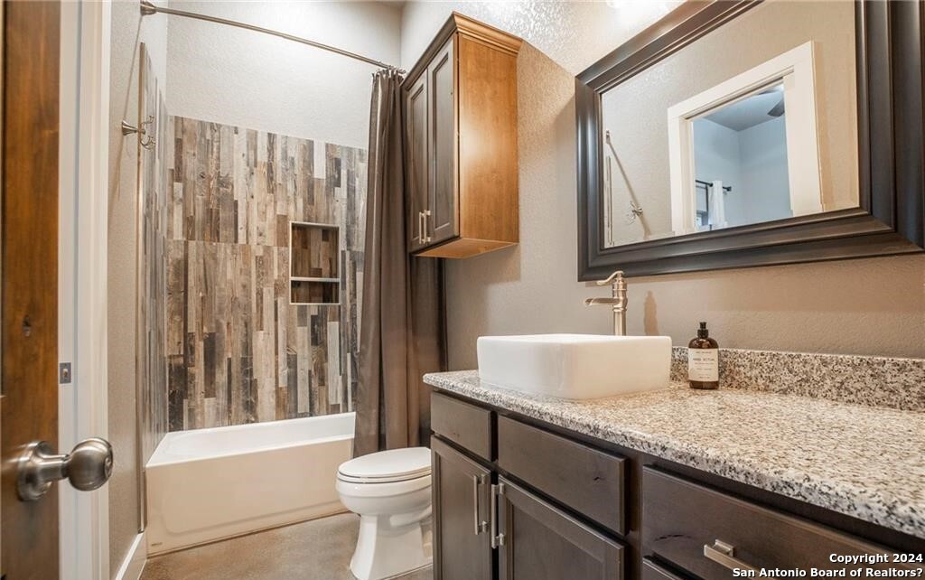 345 Laguna Road Bandera, TX 78003 - Photo 20 of 35 a bathroom with a granite countertop sink toilet and shower
