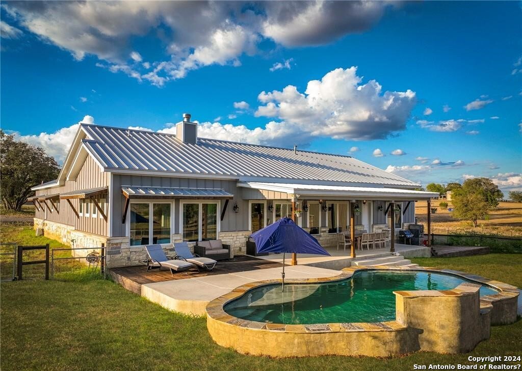 345 Laguna Road Bandera, TX 78003 - Photo 21 of 35 a view of a house with swimming pool and sitting area