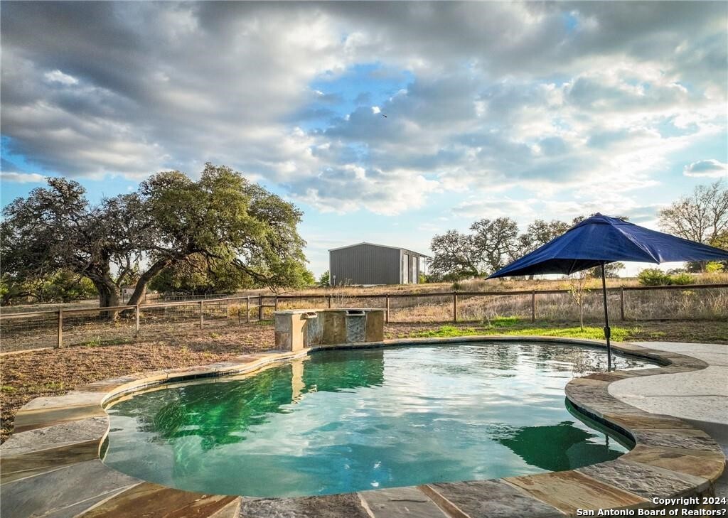 345 Laguna Road Bandera, TX 78003 - Photo 23 of 35 a view of swimming pool with lawn chairs and iron fence