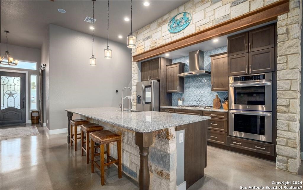 345 Laguna Road Bandera, TX 78003 - Photo 8 of 35 a kitchen with stainless steel appliances granite countertop a kitchen island a stove and a sink