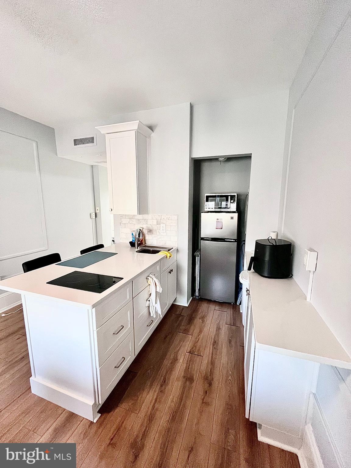 1324 Locust Street, Unit 1410 Philadelphia, PA 19107 - Photo 4 of 9 a kitchen with a stove sink and a refrigerator