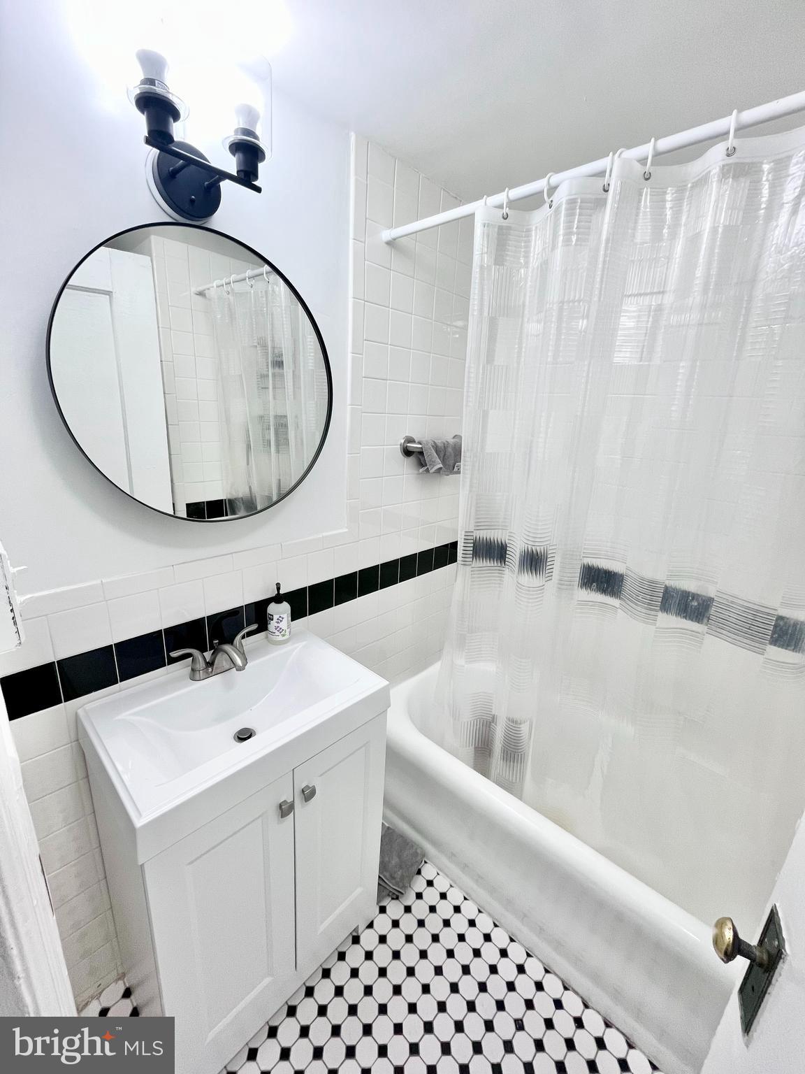 1324 Locust Street, Unit 1410 Philadelphia, PA 19107 - Photo 8 of 9 a bathroom with a sink a toilet and a mirror