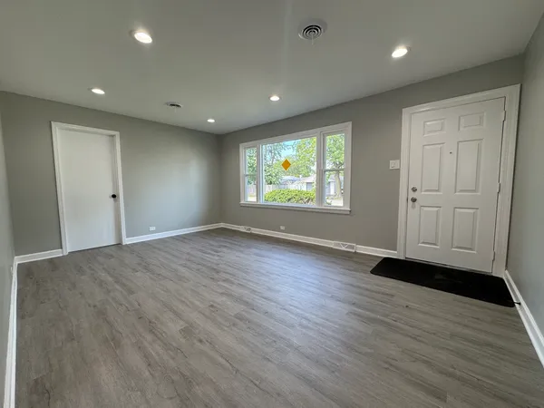 an empty room with wooden floor and window