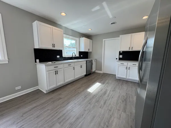 a kitchen with sink a microwave and cabinets